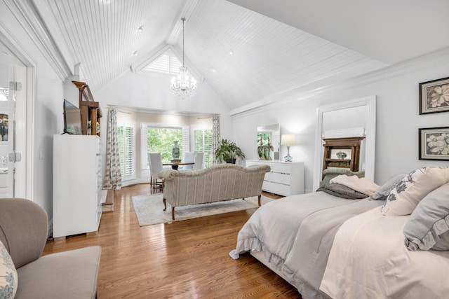 bedroom featuring a chandelier, high vaulted ceiling, and wood finished floors