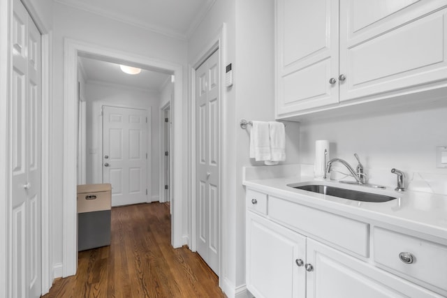 interior space featuring dark wood-type flooring, crown molding, and a sink