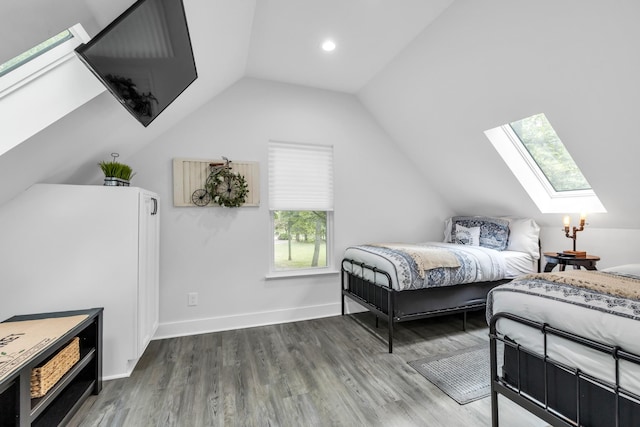 bedroom featuring baseboards, recessed lighting, wood finished floors, and lofted ceiling with skylight
