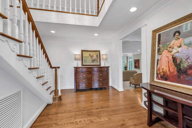 entrance foyer featuring baseboards, visible vents, stairs, and crown molding