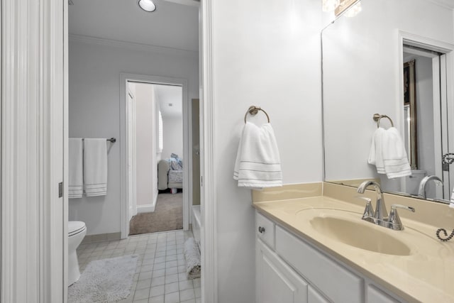 bathroom with baseboards, toilet, ornamental molding, tile patterned floors, and vanity