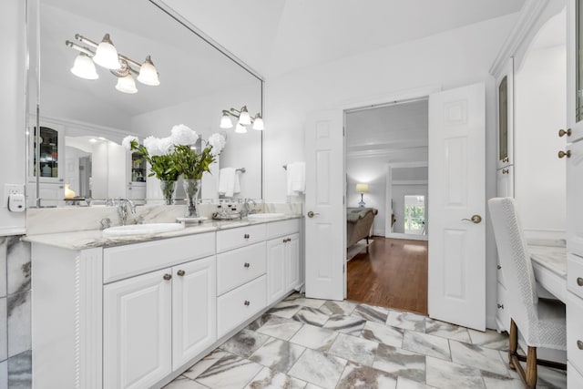 bathroom featuring double vanity, a sink, and ensuite bath