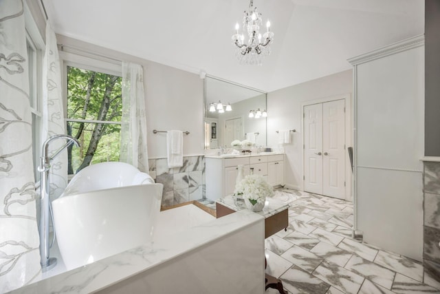 full bath with vanity, a freestanding bath, and a chandelier