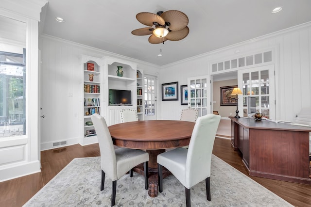 dining area with visible vents, ceiling fan, ornamental molding, and dark wood finished floors