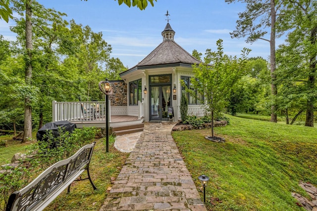 exterior space with french doors, a wooden deck, and a yard