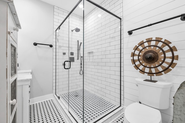 full bathroom with baseboards, a shower stall, and toilet