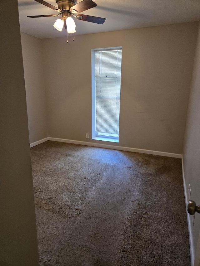 spare room featuring baseboards, a ceiling fan, and carpet