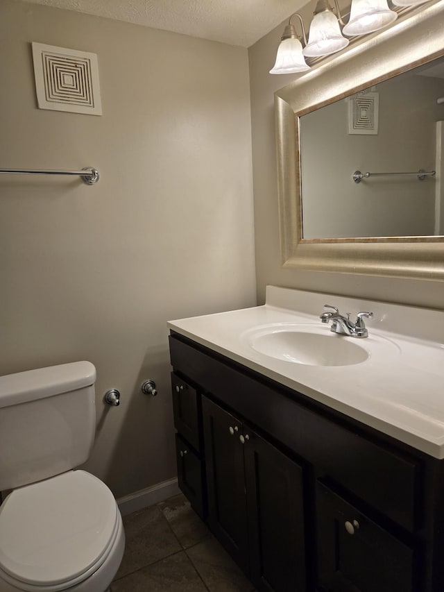 bathroom featuring vanity, toilet, visible vents, baseboards, and tile patterned flooring