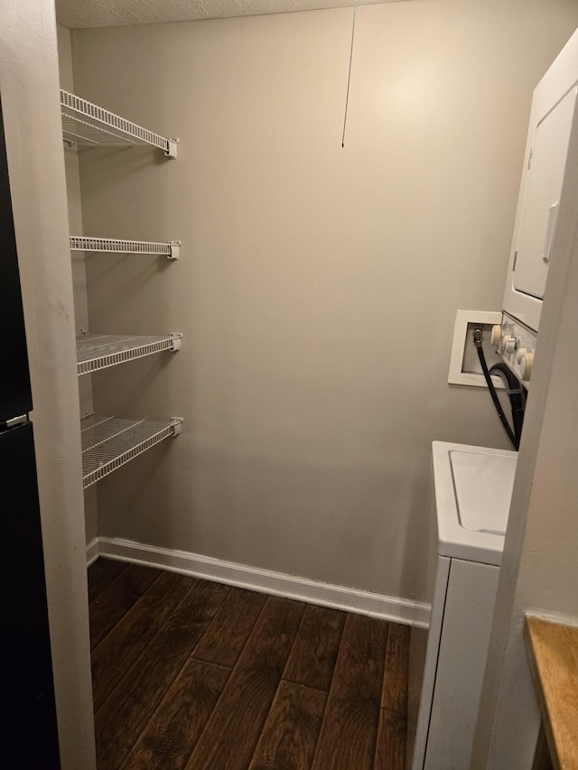 spacious closet with stacked washer / dryer and dark wood finished floors