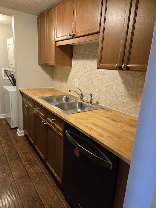 kitchen featuring a sink, dishwasher, stacked washer and clothes dryer, and butcher block countertops