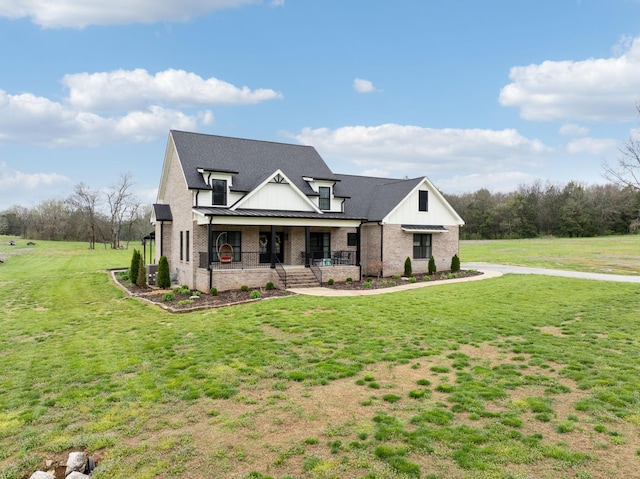 view of front of home with covered porch, brick siding, a standing seam roof, roof with shingles, and a front lawn
