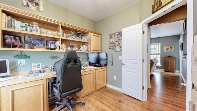 home office with baseboards, light wood-style flooring, and built in study area