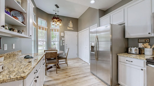kitchen featuring an inviting chandelier, stainless steel refrigerator with ice dispenser, light stone counters, light wood-style flooring, and white cabinets