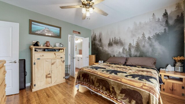 bedroom featuring ceiling fan, ensuite bath, and light wood finished floors