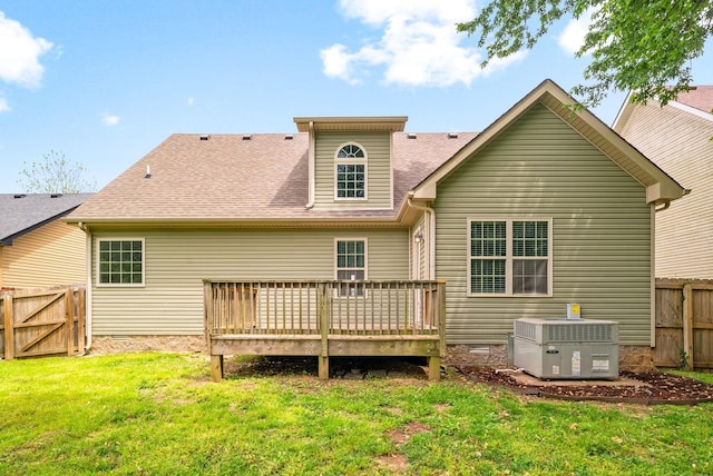 back of property featuring a yard, fence, a wooden deck, roof with shingles, and central AC
