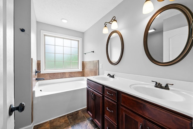 full bath featuring double vanity, stone finish floor, a bath, and a sink