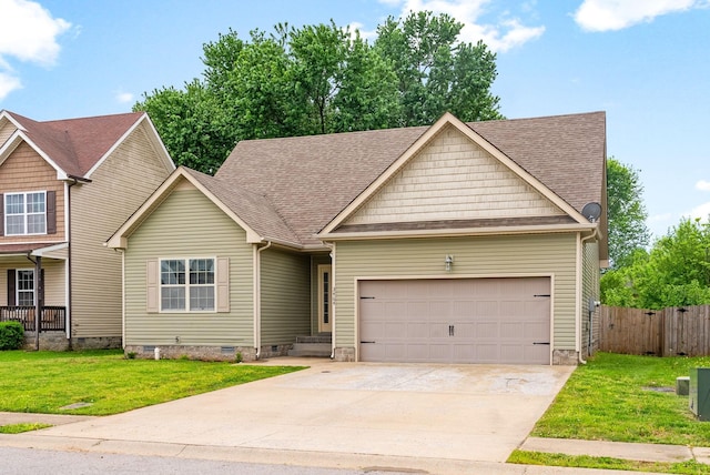 craftsman-style home featuring driveway, crawl space, fence, a front lawn, and a garage
