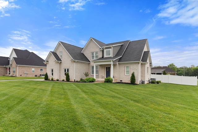 traditional-style home with brick siding, fence, and a front yard