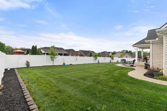 view of yard with a residential view, a patio, and a fenced backyard