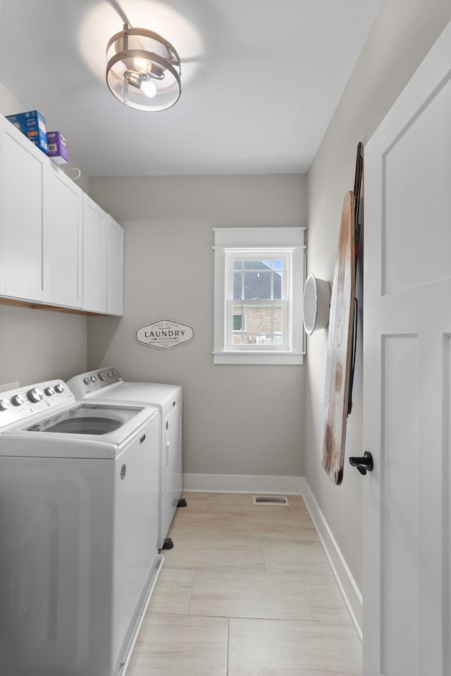 washroom featuring baseboards, visible vents, cabinet space, and washing machine and dryer
