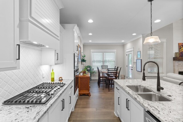 kitchen with dark wood finished floors, recessed lighting, appliances with stainless steel finishes, a sink, and pendant lighting