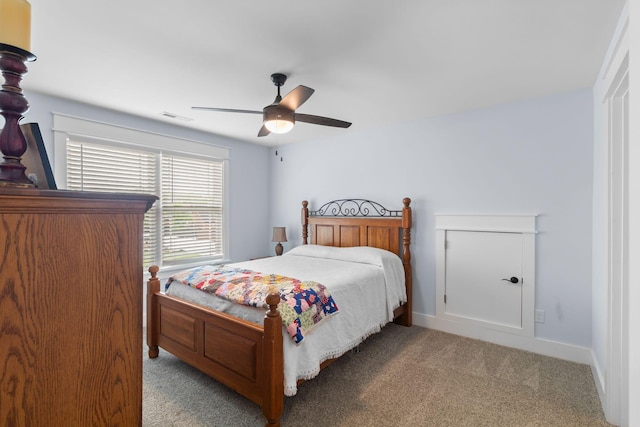 bedroom featuring baseboards, visible vents, ceiling fan, and light colored carpet