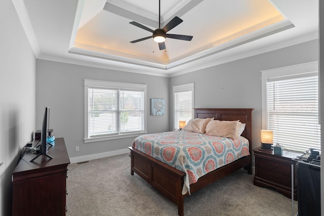 carpeted bedroom featuring crown molding, ceiling fan, a raised ceiling, and baseboards