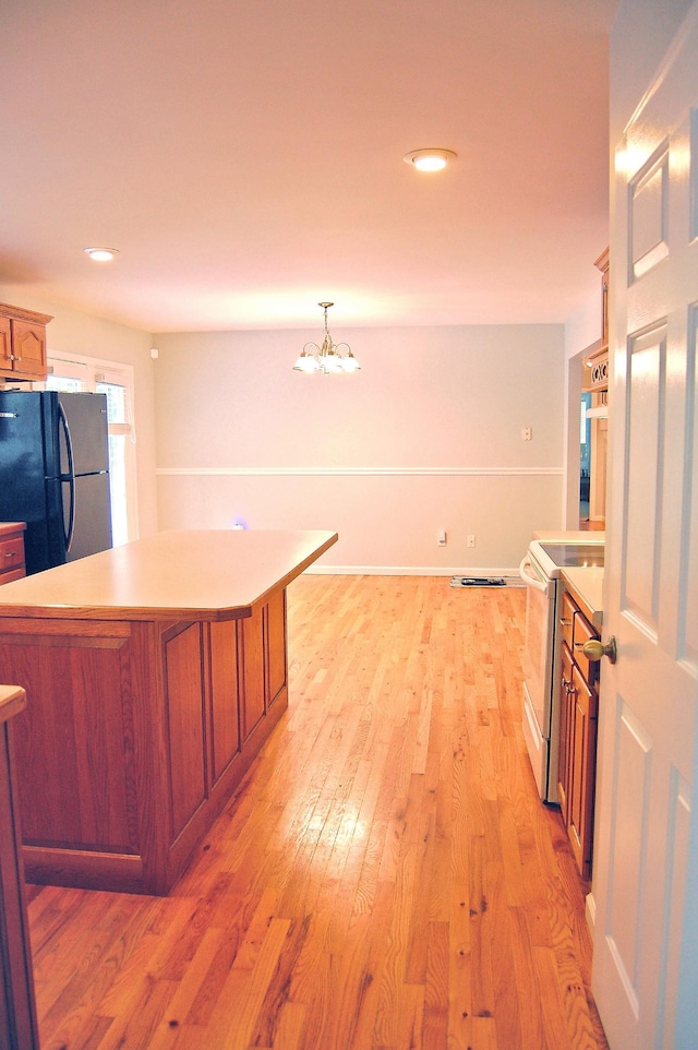 547 Grindstone Hollow Rd, Dickson, TN 37055 - kitchen featuring freestanding refrigerator, electric stove, light countertops, brown cabinetry, and light wood-style flooring