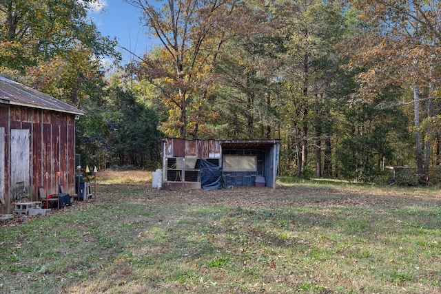 view of yard with an outdoor structure and a view of trees