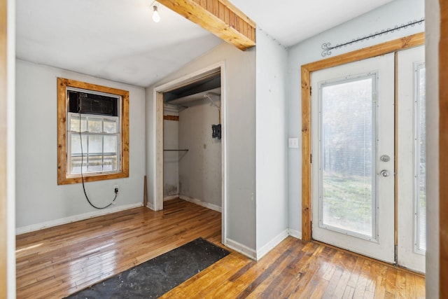 entryway with baseboards, plenty of natural light, wood-type flooring, and vaulted ceiling