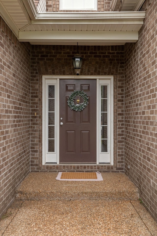 view of exterior entry featuring brick siding