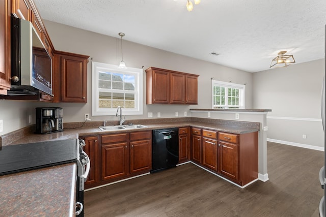 kitchen with brown cabinets, a sink, stainless steel appliances, dark wood-style flooring, and a peninsula
