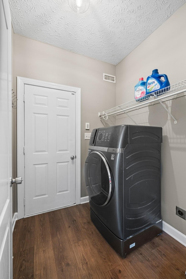 laundry area with washer / dryer, laundry area, visible vents, baseboards, and wood finished floors