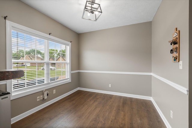 unfurnished room with dark wood-style floors and baseboards