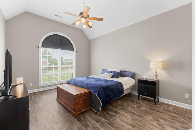 bedroom with wood finished floors, visible vents, vaulted ceiling, and baseboards