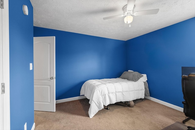bedroom with baseboards, ceiling fan, a textured ceiling, and carpet flooring