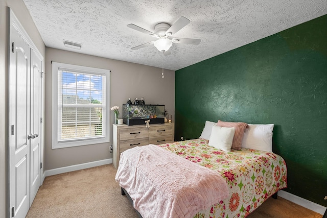 bedroom featuring a closet, visible vents, light colored carpet, and baseboards