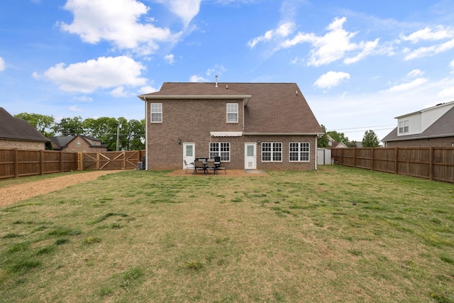back of house featuring a patio, brick siding, a fenced backyard, and a yard