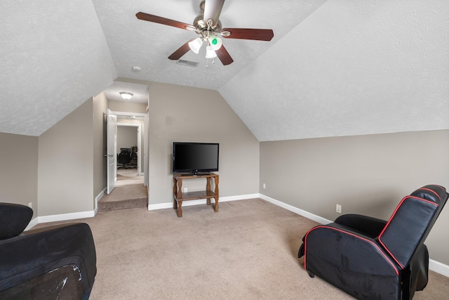 sitting room featuring baseboards, ceiling fan, carpet floors, and vaulted ceiling