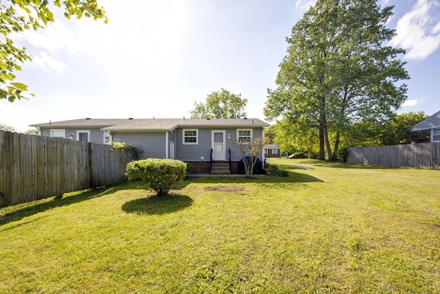 back of house featuring fence and a yard