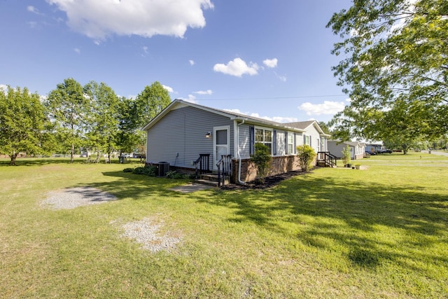 view of property exterior with cooling unit, a yard, and brick siding
