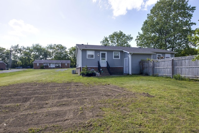 back of house featuring a lawn, fence, and entry steps