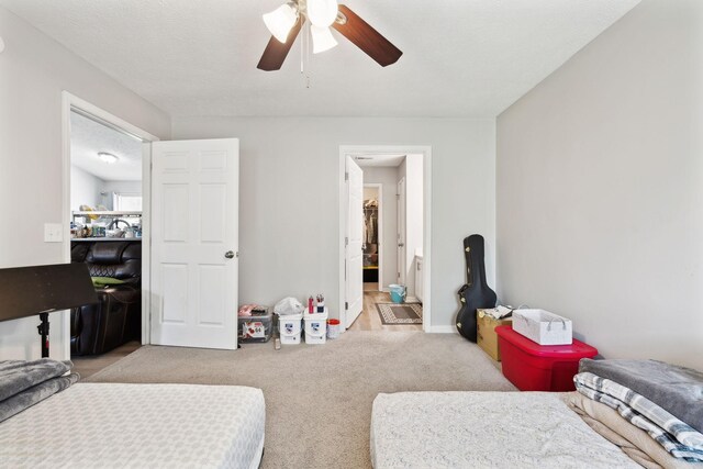bedroom featuring light colored carpet, connected bathroom, and a ceiling fan