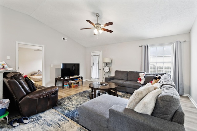 living room with wood finished floors, ceiling fan, vaulted ceiling, and baseboards