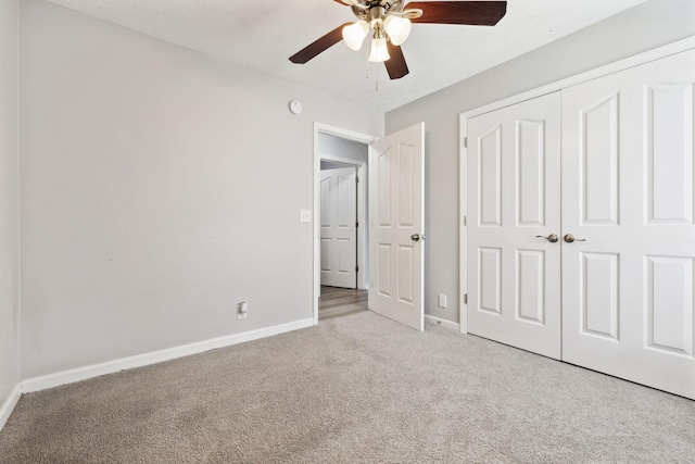 unfurnished bedroom with carpet, baseboards, a closet, and ceiling fan