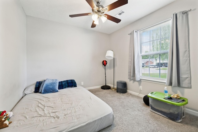 carpeted bedroom featuring baseboards and a ceiling fan