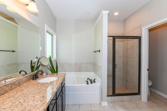 bathroom featuring tile patterned flooring, vanity, toilet, a shower stall, and a bath
