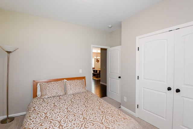 bedroom with an inviting chandelier, carpet, and a closet