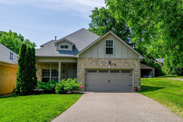craftsman-style home featuring board and batten siding, a front yard, a garage, aphalt driveway, and a shingled roof