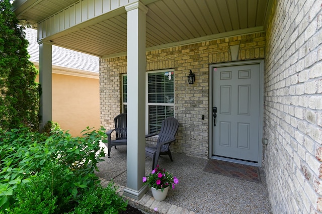 view of exterior entry featuring covered porch